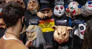 Man looks at masks in horror retail shop